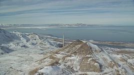 5.5K aerial stock footage fly over snowy mountains to approach Kennecott Smokestack in winter, Magna, Utah Aerial Stock Footage | AX125_292E