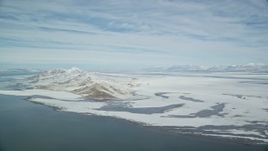 5.5K aerial stock footage of panning across snow mountains on the shore of the Great Salt Lake in Utah Aerial Stock Footage | AX125_306E