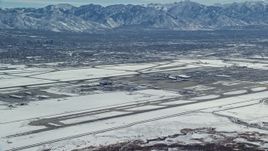 5.5K aerial stock footage of slow approach to Salt Lake City International Airport with winter snow, Utah Aerial Stock Footage | AX125_322E
