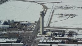 5.5K aerial stock footage reverse from control tower at Salt Lake City International Airport with winter snow, Utah Aerial Stock Footage | AX125_334