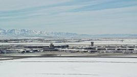 5.5K aerial stock footage of flying by the main terminal at Salt Lake City Airport with winter snow, Utah Aerial Stock Footage | AX125_337E