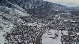 5.5K aerial stock footage pan across Interstate 215 through suburbs in Salt Lake City with winter snow, Utah Aerial Stock Footage | AX126_067