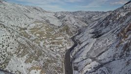 5.5K aerial stock footage of following Interstate 80 winding through the Wasatch Range with light snow, Utah Aerial Stock Footage | AX126_068E