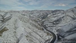 5.5K aerial stock footage of following Interstate 80 with light traffic through Wasatch Range with winter snow, Utah Aerial Stock Footage | AX126_070