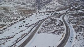 5.5K aerial stock footage approach light traffic on Interstate 80 through the Wastach Range with snow, Utah Aerial Stock Footage | AX126_075E