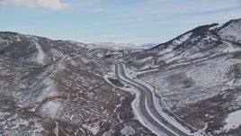 5.5K aerial stock footage pan across freeway through snowy mountain pass in winter, Wasatch Range, Utah Aerial Stock Footage | AX126_081E