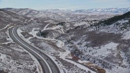 5.5K aerial stock footage fly over freeway with light traffic through wintery mountain pass with snow, Wasatch Range, Utah Aerial Stock Footage | AX126_084E