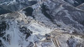 5.5K aerial stock footage orbit the tracks and ski jumps at Utah Olympic Park with winter snow, Park City Aerial Stock Footage | AX126_098