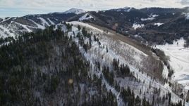 5.5K aerial stock footage orbit gondolas running up a snowy mountain slope in Park City, Utah Aerial Stock Footage | AX126_120