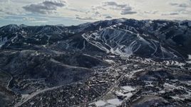 5.5K aerial stock footage of reverse view of Park City Mountain Resort slopes beside the town in winter, Utah Aerial Stock Footage | AX126_152E