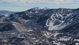 5.5K aerial stock footage a small town between snowy hills and mountains in winter, Park City, Utah Aerial Stock Footage | AX126_159E