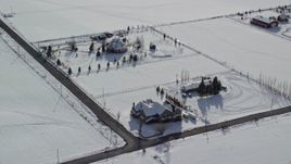 5.5K aerial stock footage orbit three large homes by snowy fields in wintertime, Midway, Utah Aerial Stock Footage | AX126_214