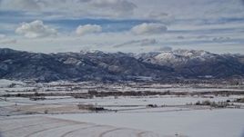 5.5K aerial stock footage of small town at the base of snowy mountain range in winter, Heber City, Utah Aerial Stock Footage | AX126_218E