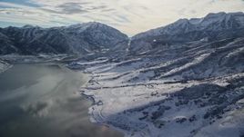 5.5K aerial stock footage approach snowy shore and mountains by the Deer Creek Reservoir in winter, Utah Aerial Stock Footage | AX126_227E