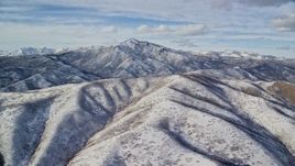 5.5K aerial stock footage a snowy Wasatch Range mountain with taller peak in the distance, Utah Aerial Stock Footage | AX126_232E