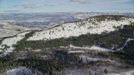 5.5K aerial stock footage approach snowy mountain ridge ringed by evergreen forest in winter, Wasatch Range, Utah Aerial Stock Footage | AX126_279E
