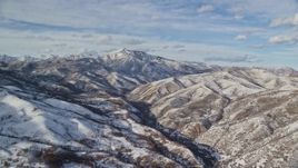 5.5K aerial stock footage of Mill Canyon Peak with winter snow seen from Deer Creek Reservoir, Utah Aerial Stock Footage | AX126_304E