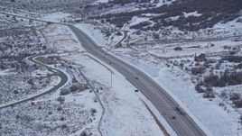 5.5K aerial stock footage orbit a country road through winter Snow with light traffic, Wasatch Range, Utah Aerial Stock Footage | AX126_309