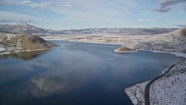 5.5K aerial stock footage of passing a highway on the shore of the reservoir and approach Heber City in winter, Utah Aerial Stock Footage | AX126_313E