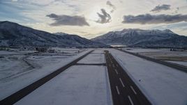 5.5K aerial stock footage of lifting off from Heber City Municipal Airport with winter snow, Utah Aerial Stock Footage | AX127_001E