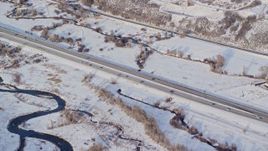 5.5K aerial stock footage of light traffic on highway through snowy countryside in winter, Heber City, Utah Aerial Stock Footage | AX127_009E