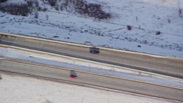 5.5K aerial stock footage of tracking a black truck on a county highway and crossing a small bridge in winter, Heber City, Utah Aerial Stock Footage | AX127_012