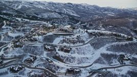 5.5K aerial stock footage orbit several mountaintop mansions with winter snow in Deer Valley at sunset, Utah Aerial Stock Footage | AX127_018E