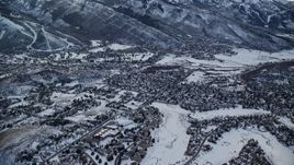 5.5K aerial stock footage of flying by small town residential neighborhoods with winter snow at sunset, Park City, Utah Aerial Stock Footage | AX127_025