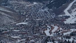 5.5K aerial stock footage of Park City at sunset in the shadow of a snowy mountain in winter, Utah Aerial Stock Footage | AX127_029E