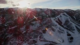 5.5K aerial stock footage orbit snowy mountains in winter with the sun above, Wasatch Range, Utah Aerial Stock Footage | AX127_033