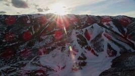 5.5K aerial stock footage orbit Wasatch Range snow mountains with the sun over them, Utah Aerial Stock Footage | AX127_034