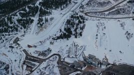 5.5K aerial stock footage reverse view of the aerials pool and ski jumps at Utah Olympic Park with winter snow at sunset, Utah Aerial Stock Footage | AX127_038