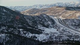 5.5K aerial stock footage approach I-80 and homes on snowy mountain slopes at sunset in winter, Park City, Utah Aerial Stock Footage | AX127_041E