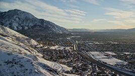 5.5K aerial stock footage of suburban neighborhoods at the foot of snowy mountains in Salt Lake City at sunset, Utah Aerial Stock Footage | AX127_074
