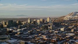 5.5K stock footage video of passing by Downtown Salt Lake City near Utah State Capitol with winter snow at sunset Aerial Stock Footage | AX127_106
