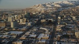 5.5K aerial stock footage reverse view of streets through Downtown Salt Lake City to Utah State Capitol at sunset with winter snow Aerial Stock Footage | AX127_130