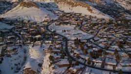 5.5K aerial stock footage approach and flyby hillside neighborhood by snowy slopes at sunset, Salt Lake City, Utah Aerial Stock Footage | AX127_143E
