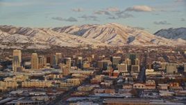 5.5K aerial stock footage of downtown area of Salt Lake City and snowy mountains at sunset, Utah Aerial Stock Footage | AX127_151E