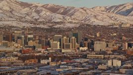 5.5K aerial stock footage of tall buildings in Downtown Salt Lake City and frozen mountains in the background at sunset, Utah Aerial Stock Footage | AX127_153