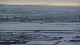 5.5K aerial stock footage orbit SLC Airport with winter snow as an airliner races by at sunset, Utah Aerial Stock Footage | AX127_170