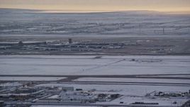 5.5K aerial stock footage of SLC Airport with winter snow as an airliner races by at sunset, Utah Aerial Stock Footage | AX127_170E