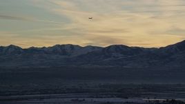5.5K aerial stock footage track commercial jet over snowy mountains by Salt Lake City at sunset in winter, Utah Aerial Stock Footage | AX127_174