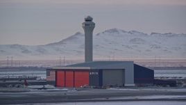 5.5K aerial stock footage orbit Delta Hangar and airport control tower with winter snow at sunset, Salt Lake City, Utah Aerial Stock Footage | AX127_175