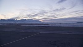 5.5K aerial stock footage of low altitude approach to taxiways and winter snow at SLC Airport at sunset, Utah Aerial Stock Footage | AX128_003