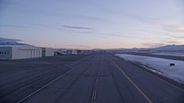 5.5K aerial stock footage of ascending near hangars and parked planes at SLC Airport in winter at sunset, Utah Aerial Stock Footage | AX128_004