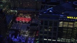 5.5K aerial stock footage orbit office building and reveal Gallivan Center lights and ice rink at night, Downtown Salt Lake City, Utah Aerial Stock Footage | AX128_096