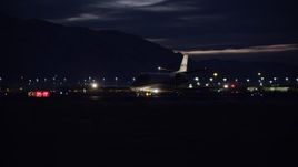 5.5K aerial stock footage of tracking a private jet taxiing at SLC Airport at night in winter, Utah Aerial Stock Footage | AX128_122