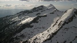 5.5K aerial stock footage of passing by Lone Peak in snowy Wasatch Range, Utah Aerial Stock Footage | AX129_120E