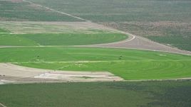 5.5K aerial stock footage of flying by circular crop fields, tractors, Cedar Fort, Utah Aerial Stock Footage | AX130_078
