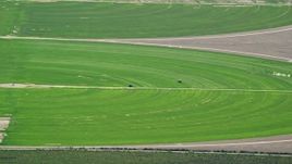 5.5K aerial stock footage of passing by circular crop fields, tractors, Cedar Fort, Utah Aerial Stock Footage | AX130_079